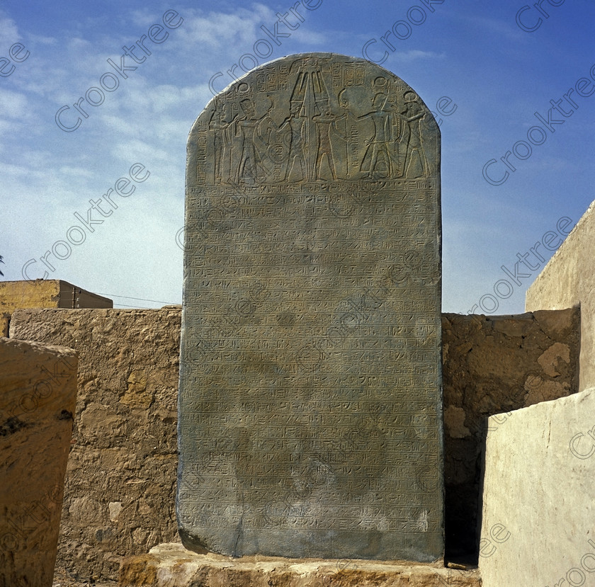 Merneptah Stele EG05142jhp 
 Egypt Merneptah Merenptah Israeli stele replica entrance 6x6 120 medium format slide West Bank Luxor, an Egyptian Pharaoh who reigned around 1212-1202BC, son of Ramasses 11, is on the West Bank of the Nile at Luxor and this photo was taken from the main West bank road looking towards the River Nile and with the Ramasseum towards the extreme left. A new museum and some excavated parts of his temple were opened in 2005. It is a mixture of open air and covered museum exhibits with some remains of the temple area with column bases. Some of the coloured wall reliefs are exquisite and because of the natural light available were easily photographed despite being inside. There is also a replica of the famous Israeli Stele, the original being in the Cairo Museum. This is a visit that would have to made outwith the usual West Bank package tour although easily arranged and is easily found next to the Ramasseum. 
 Keywords: Egypt, Luxor, Thebes, West, Bank, River, Nile, temple, mortuary, Qurna, Merneptah, Merenptah, pharaoh, 1212BC, mudbrick, pylon, ruins, walls, foundations, history, ancient, Egyptian, antiquity, archaeology, Egyptology, restoration, excavation, museum, wall, reliefs, paintings, colourful, colorful, colours, colors, evening, light, fertile, crops, roadside, view, Ramasseum, Ramses, son, Ramasses, May, 2005, slide, film, Fuji, RDP 111, Provia, 6x6, 120, medium, square, format, Yashica, Mat 124G, scanned, scan