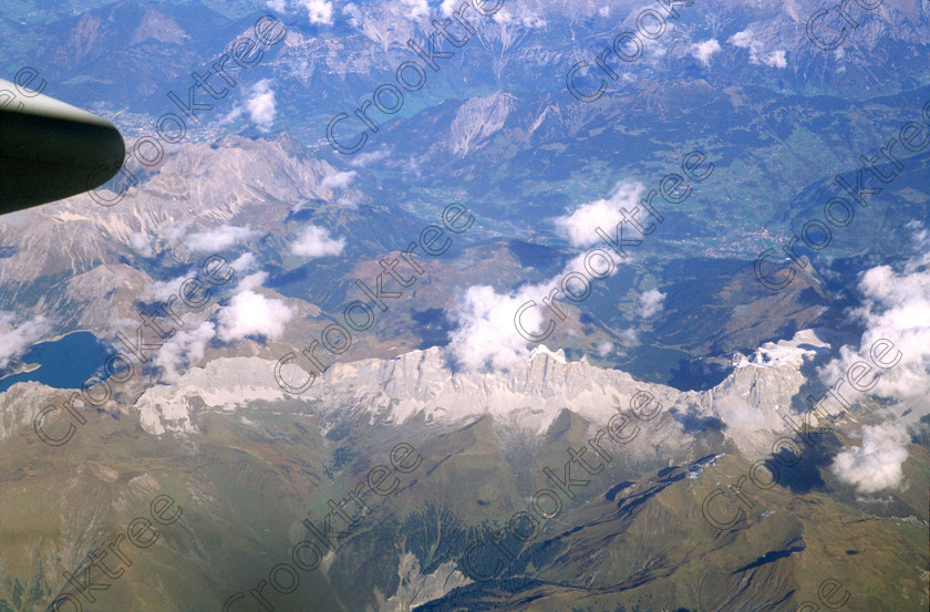 EG017213jhp Aerial Dolomites 
 Dolomites mountains Italy aircraft flying high snow topped clouds cumulus holiday flight after a Kuoni Egyptian package including Nile and Lake Nasser cruise returning to the UK in an Egyptair Airbus on the trip home from Luxor to Heathrow via Cairo. After crossing the Mediterranean the usual route was along the Adriatic Italian coast crossing the Dolomites and Alps, across France and into Heathrow. 
 Keywords: Cairo, London, Heathrow, France, Italy, flying, aircraft, aerial, clouds, desert, Sahara, Egypt, shapes, fascinating, air, high, height, looking, down, cumulus, scattered, random, heat, pattern, surreal, abstract, white, panorama, holiday, 2001, Fuji, Velvia, 35mm slide, film, scanned, scan, landscape, Egyptair, Airbus, jet, engine, turbine, window, mountains, Alps, Dolomites, cruiseboat, cruise, tourism, tourist, package, Kuoni, travel, history, antiquity, Egyptology, domestic, international, visitors, holiday, sky, blue, snow, evening, shadows, misty, pastel, dreamy, soaring, Nature, smog, pollution, hazy, polarised
